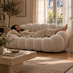 A woman lying full length on the AP-89 2 seat sofa in Cloud White, feet up, with room to spare