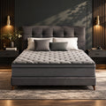 Rest Hybrid Mattress on an upholstered bed in a warm, dark bedroom