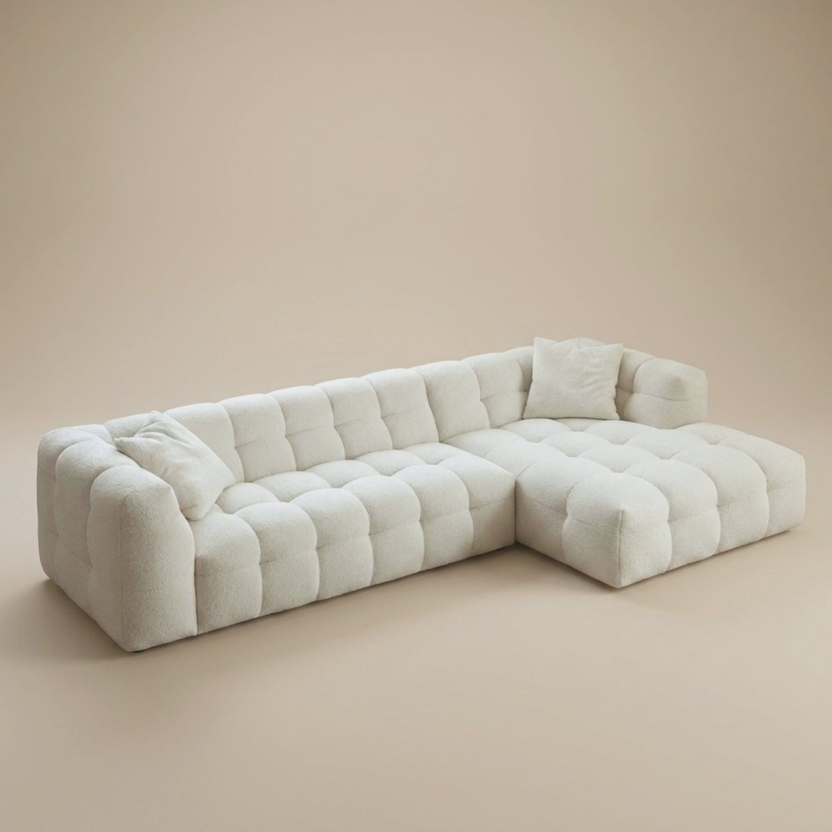 A woman sits down on the Cloud Corner Sectional in Cloud White and the bouclé cushions compress beneath her